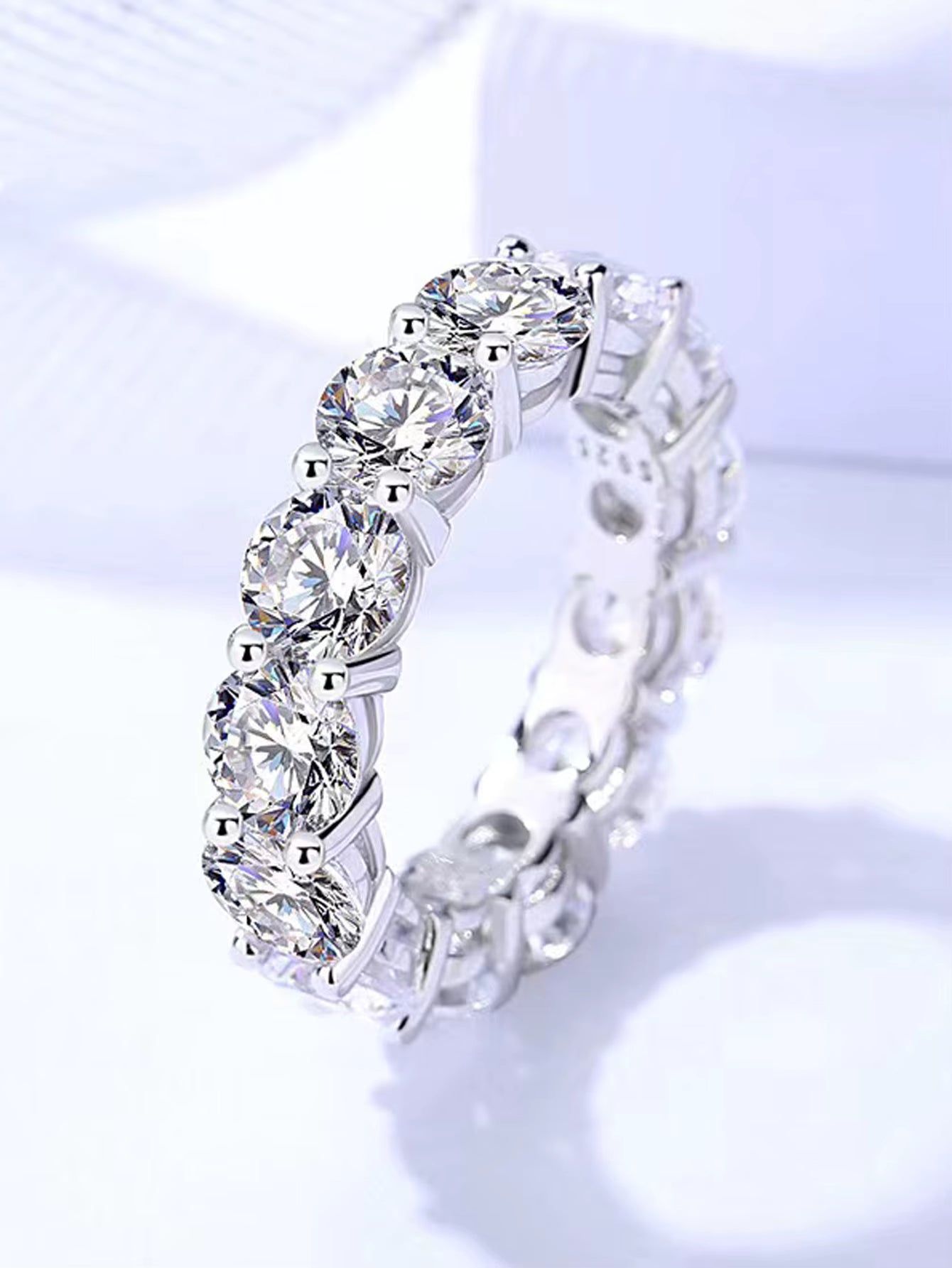 Amor Ring elegant auf Schmuckdisplay präsentiert – 925 Silber mit VS1–VVS Moissanite-Steinen, brillant, rhodiniert und zeitlos.