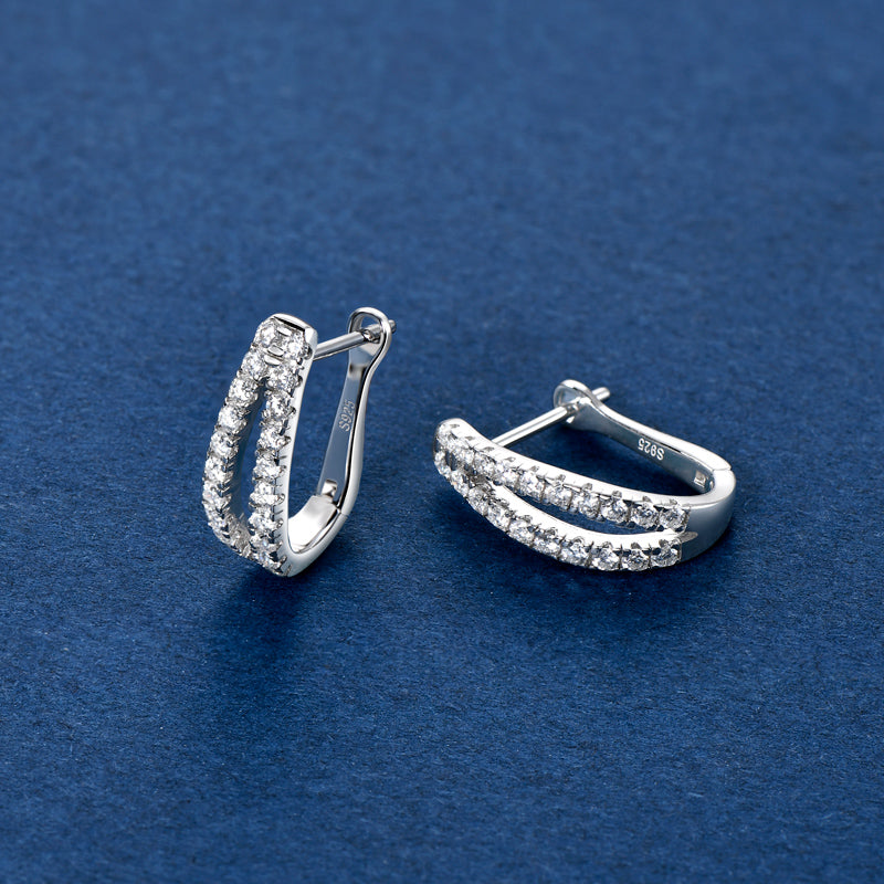 Double Glow Creolen von NOBEL Jewelry auf blauem Hintergrund – edles 925 Silber, doppelte Moissanite-Reihe, diamantähnlicher Glanz und elegante Ausstrahlung.