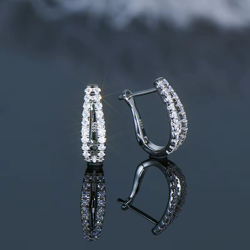 NOBEL Double Glow Creolen auf dunklem Hintergrund – 925 Silber mit zwei Reihen funkelnder Moissanite-Steine, rhodiniert, wasserfest und luxuriös.