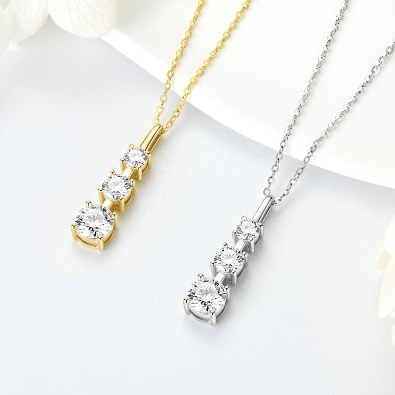 Drop Ketten in Gold und Rhodium nebeneinander auf Schmuckdisplay – 925 Silber mit tropfenförmigem VS1–VVS Moissanite, wasserfest, hypoallergen und brillant.